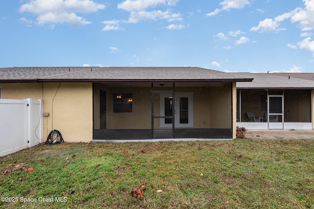 rear view of house with a yard and a sunroom