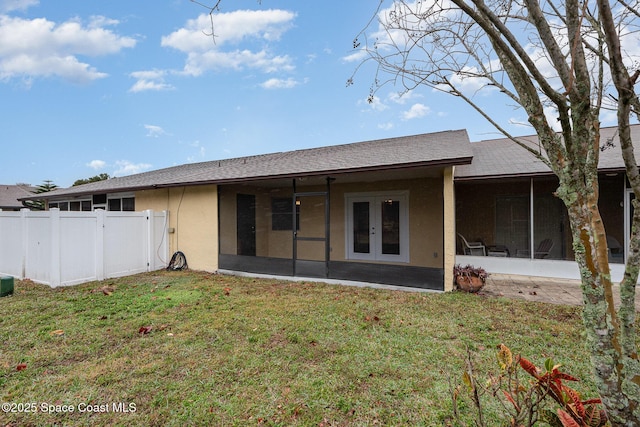 rear view of property with french doors, a yard, and a sunroom