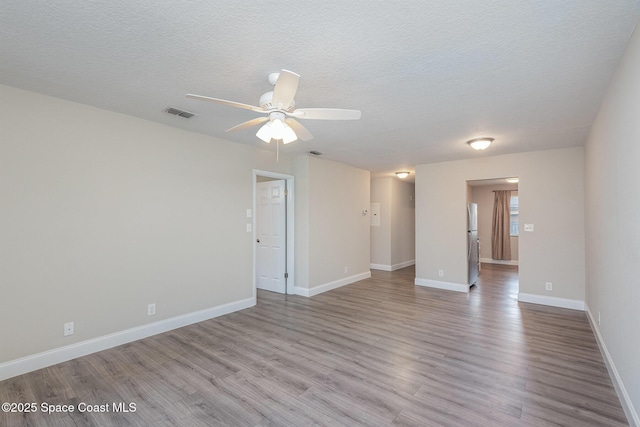 unfurnished room featuring ceiling fan, a textured ceiling, and light wood-type flooring