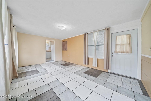 empty room featuring light tile patterned floors and a textured ceiling