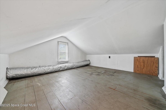 additional living space with vaulted ceiling and hardwood / wood-style floors