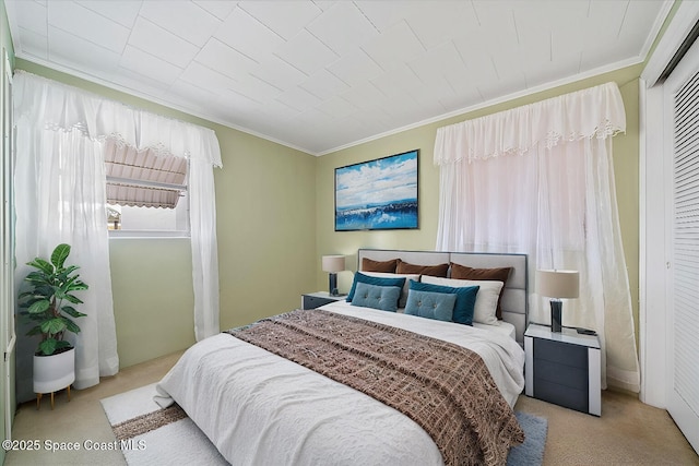 bedroom with light colored carpet, ornamental molding, and a closet