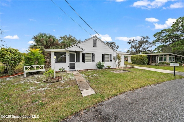 view of front of home featuring a front yard and a sunroom