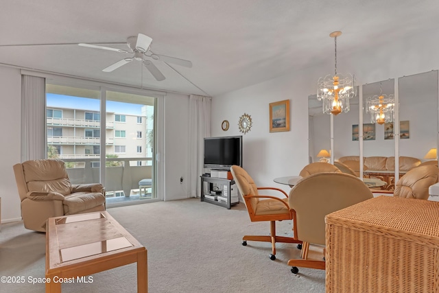 carpeted living area with ceiling fan with notable chandelier