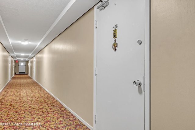 corridor with carpet floors and baseboards