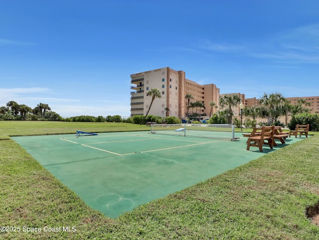 view of tennis court with a yard