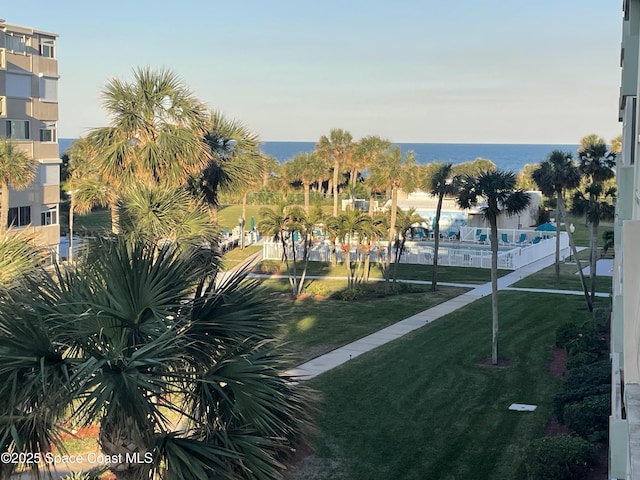 surrounding community featuring a lawn and a water view