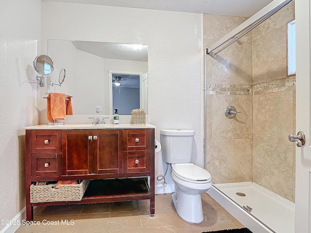 bathroom featuring vanity, a shower with shower door, tile patterned floors, and toilet