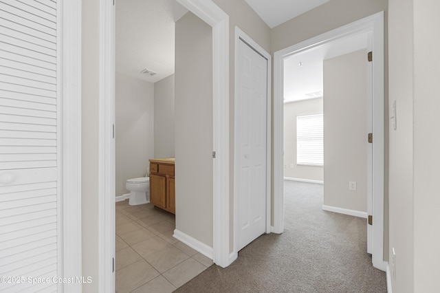 hallway featuring light colored carpet