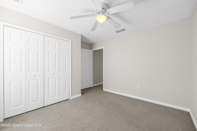 unfurnished bedroom with light colored carpet, ceiling fan, and a closet