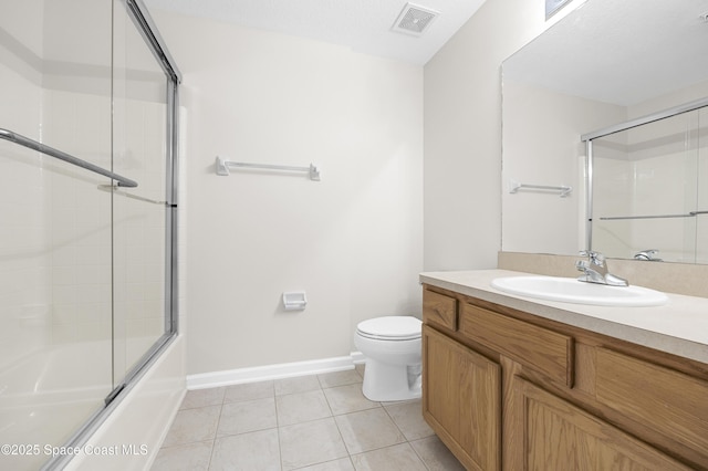 full bathroom with bath / shower combo with glass door, vanity, tile patterned floors, and toilet