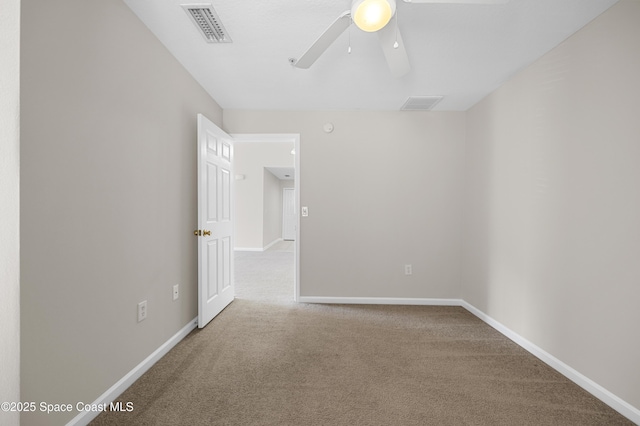 spare room with ceiling fan and carpet