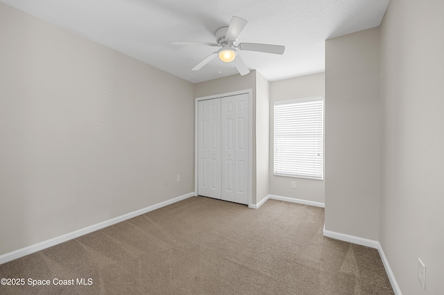 unfurnished bedroom featuring light carpet, ceiling fan, and a closet