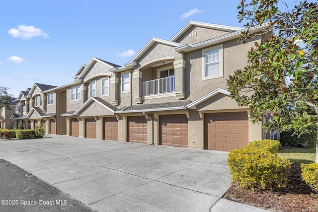 townhome / multi-family property featuring a balcony and a garage