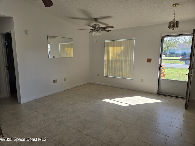 spare room with ceiling fan, light tile patterned floors, and a textured ceiling