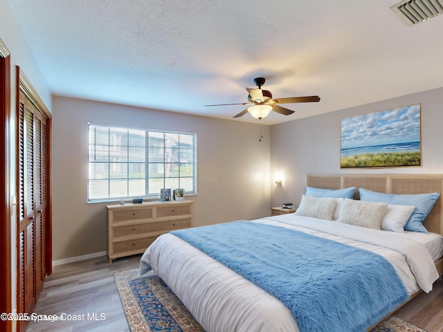 bedroom with ceiling fan, a closet, and hardwood / wood-style floors