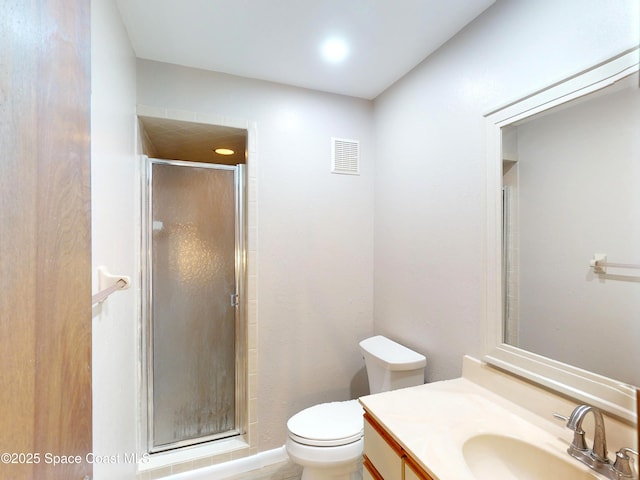 bathroom with a shower with shower door, vanity, and toilet