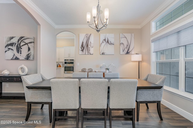 7690 Kerrington Dr, Melbourne, FL 32940 - dining space featuring dark wood-type flooring, ornamental molding, and a chandelier