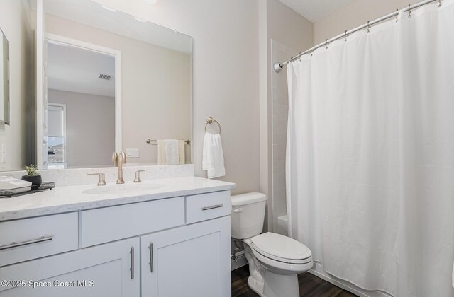 7690 Kerrington Dr, Melbourne, FL 32940 - bathroom with vanity, hardwood / wood-style floors, and toilet