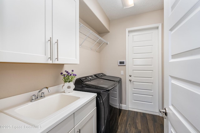 7690 Kerrington Dr, Melbourne, FL 32940 - laundry room featuring sink, dark hardwood / wood-style floors, cabinets, a textured ceiling, and washing machine and clothes dryer