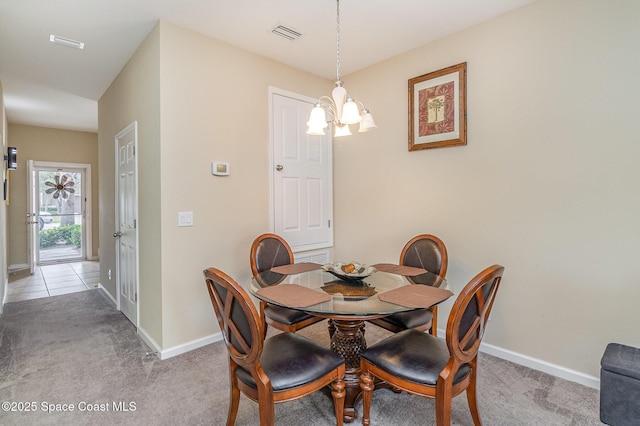 dining room with light colored carpet and a chandelier