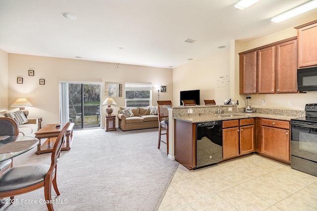 kitchen with black appliances, light stone countertops, sink, kitchen peninsula, and light colored carpet