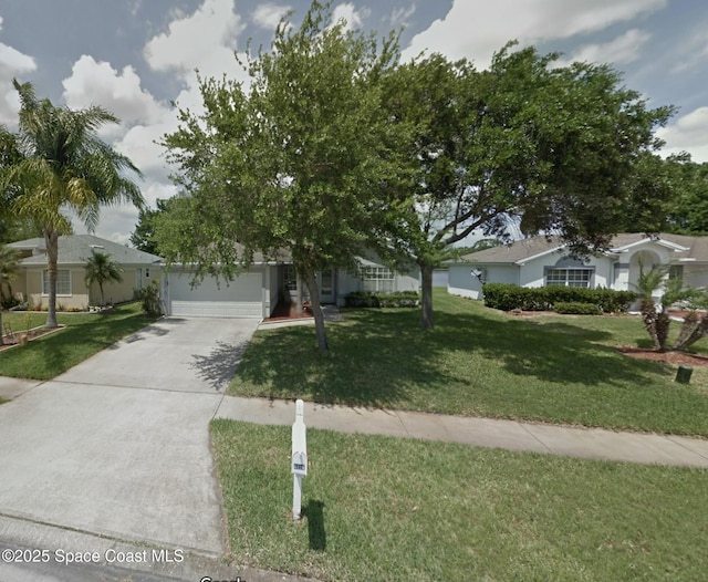 view of property hidden behind natural elements featuring a garage and a front yard