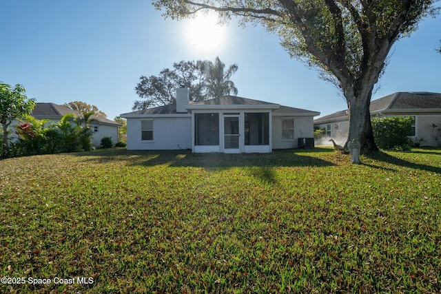 back of house featuring central AC unit, a yard, and a sunroom