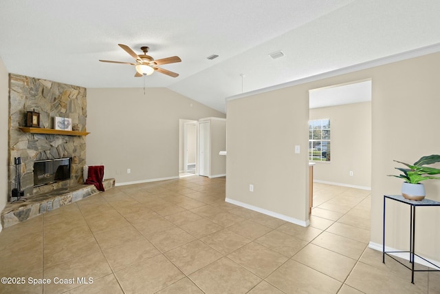 tiled living room with ceiling fan, vaulted ceiling, a textured ceiling, and a fireplace