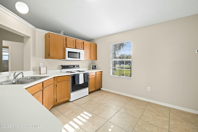 kitchen featuring light tile patterned flooring, sink, a textured ceiling, and white appliances