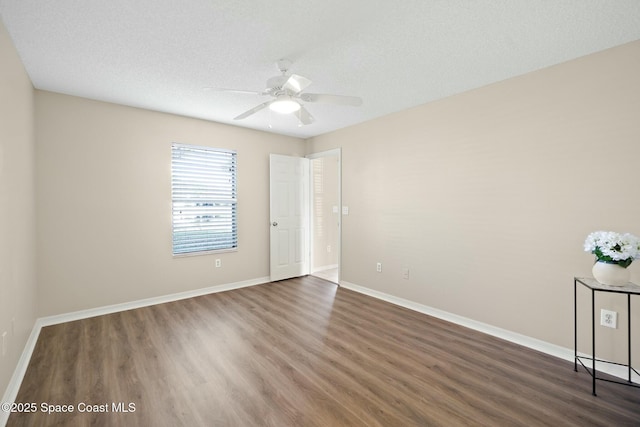 unfurnished room with ceiling fan, dark hardwood / wood-style flooring, and a textured ceiling