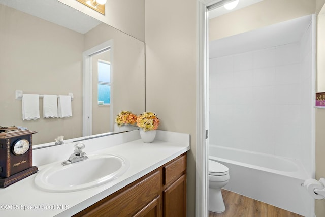 full bathroom with vanity, wood-type flooring, washtub / shower combination, and toilet