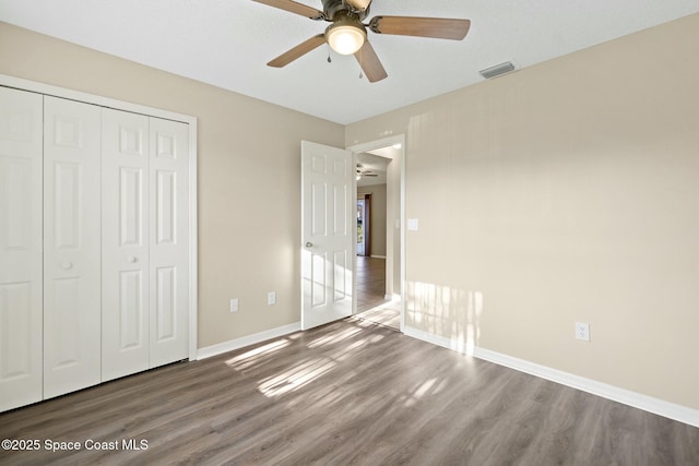 unfurnished bedroom featuring wood-type flooring, ceiling fan, and a closet