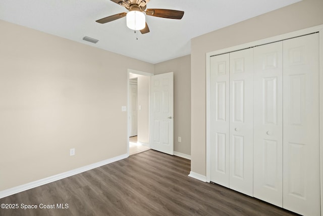 unfurnished bedroom featuring dark hardwood / wood-style flooring, a closet, and ceiling fan