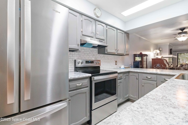 kitchen featuring ceiling fan, appliances with stainless steel finishes, decorative backsplash, and gray cabinets