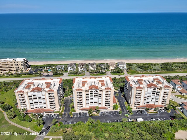 birds eye view of property with a water view and a beach view