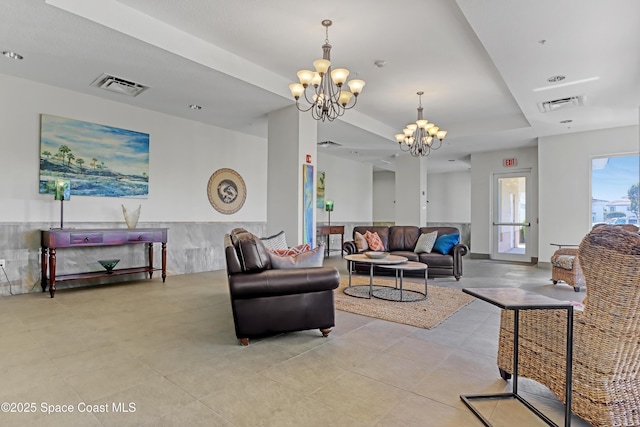 living room featuring a tray ceiling and a chandelier