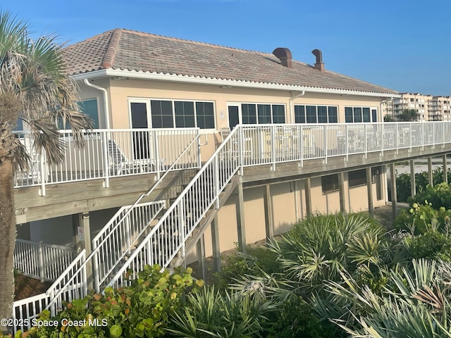 rear view of house featuring a wooden deck