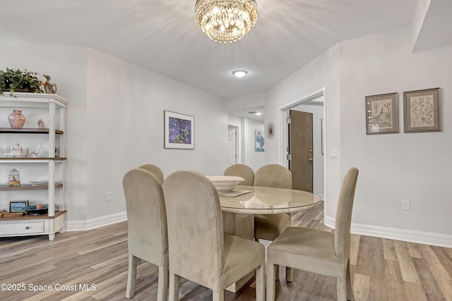 dining space with a chandelier and light wood-type flooring