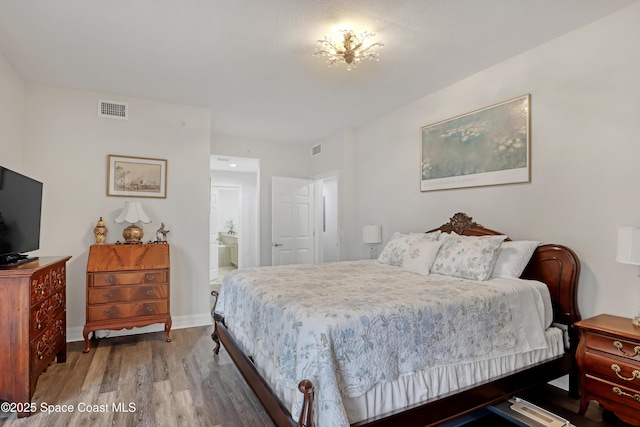 bedroom featuring connected bathroom and hardwood / wood-style floors