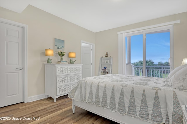 bedroom with hardwood / wood-style floors and access to outside