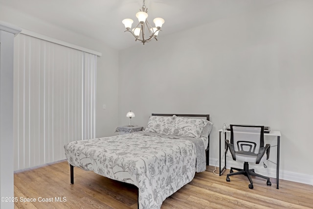 bedroom with hardwood / wood-style flooring and a notable chandelier