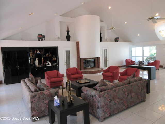 tiled living room with ceiling fan and high vaulted ceiling