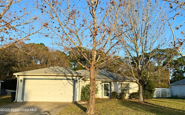 ranch-style house featuring fence, concrete driveway, a front yard, stucco siding, and a garage