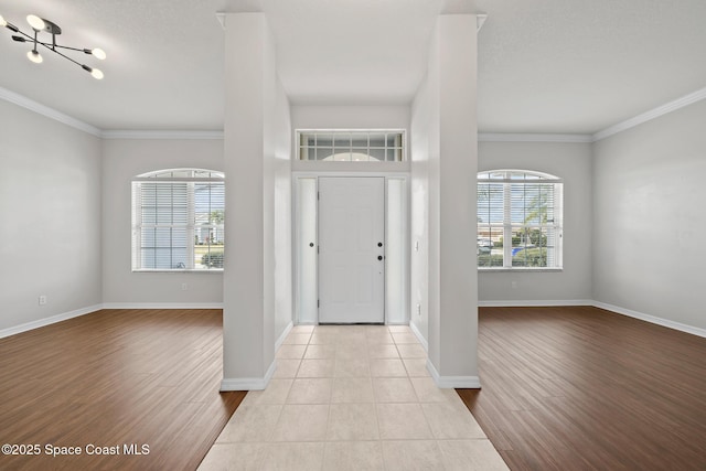 entryway with crown molding and light hardwood / wood-style flooring