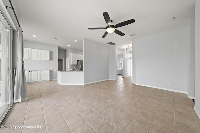 unfurnished living room with ceiling fan, light tile patterned floors, and sink