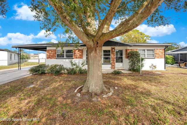 1008 Jersey St, Cocoa, FL 32927 - ranch-style home featuring brick siding, an attached carport, and driveway