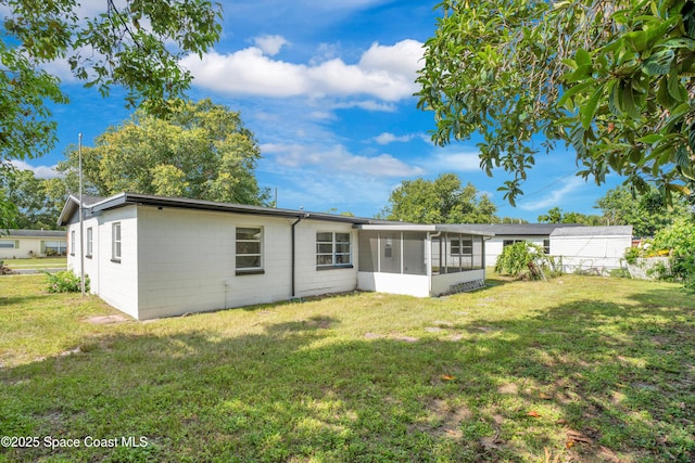 1008 Jersey St, Cocoa, FL 32927 - rear view of house with a sunroom, a lawn, and concrete block siding