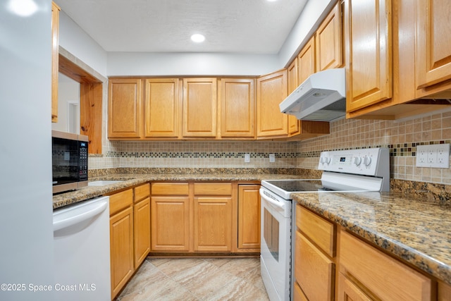 1008 Jersey St, Cocoa, FL 32927 - kitchen with white appliances, under cabinet range hood, decorative backsplash, recessed lighting, and light stone countertops