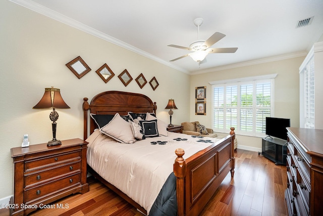 bedroom featuring ceiling fan, dark hardwood / wood-style flooring, and ornamental molding